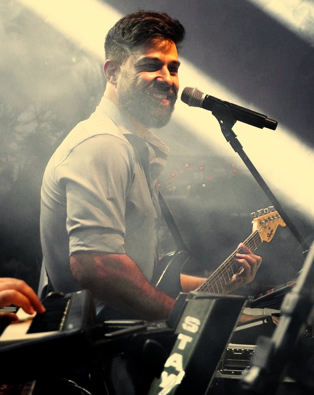 Paulo Henri cantando e tocando violão no palco